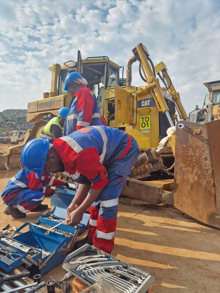 Technicians servicing a Caterpillar bulldozer on site